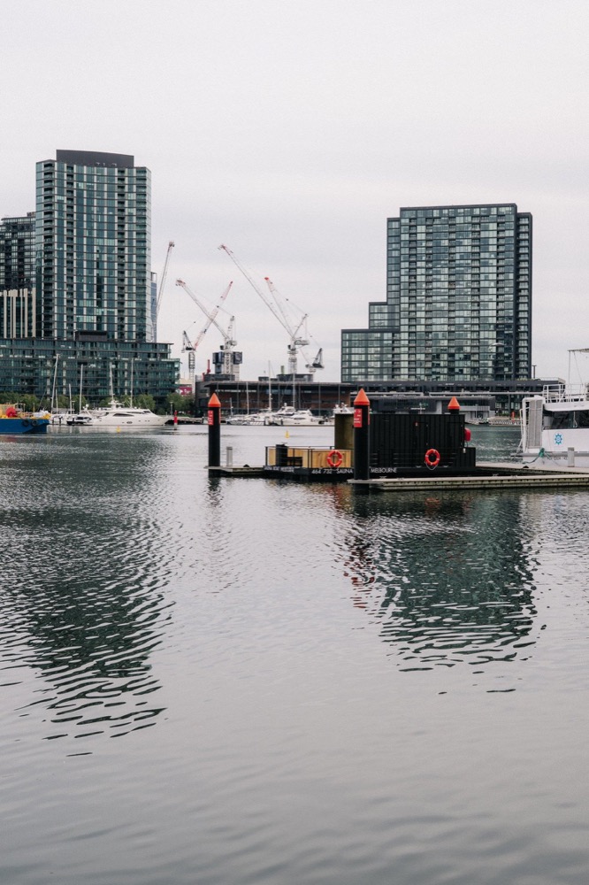Sauna Boat Melbourne moored in Docklands with city buildings behind